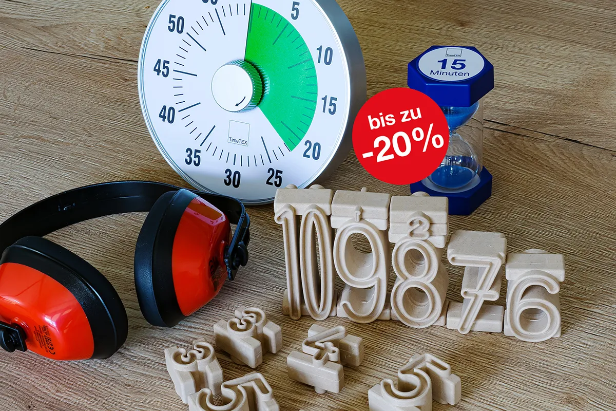 Auf einen Tisch liegen ein roter Gehörschutz eine Zeitdauer-Uhr und eine Sanduhr