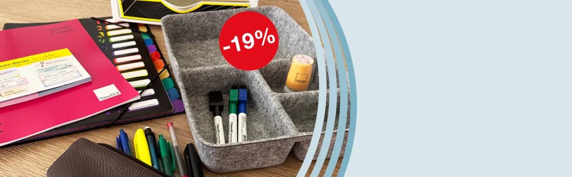 Auf einem Tisch liegen Planer, eine Fächermappe, Haftnotizen und eine graue Organisator-Box aus Filz mit Stiften und Stempeln