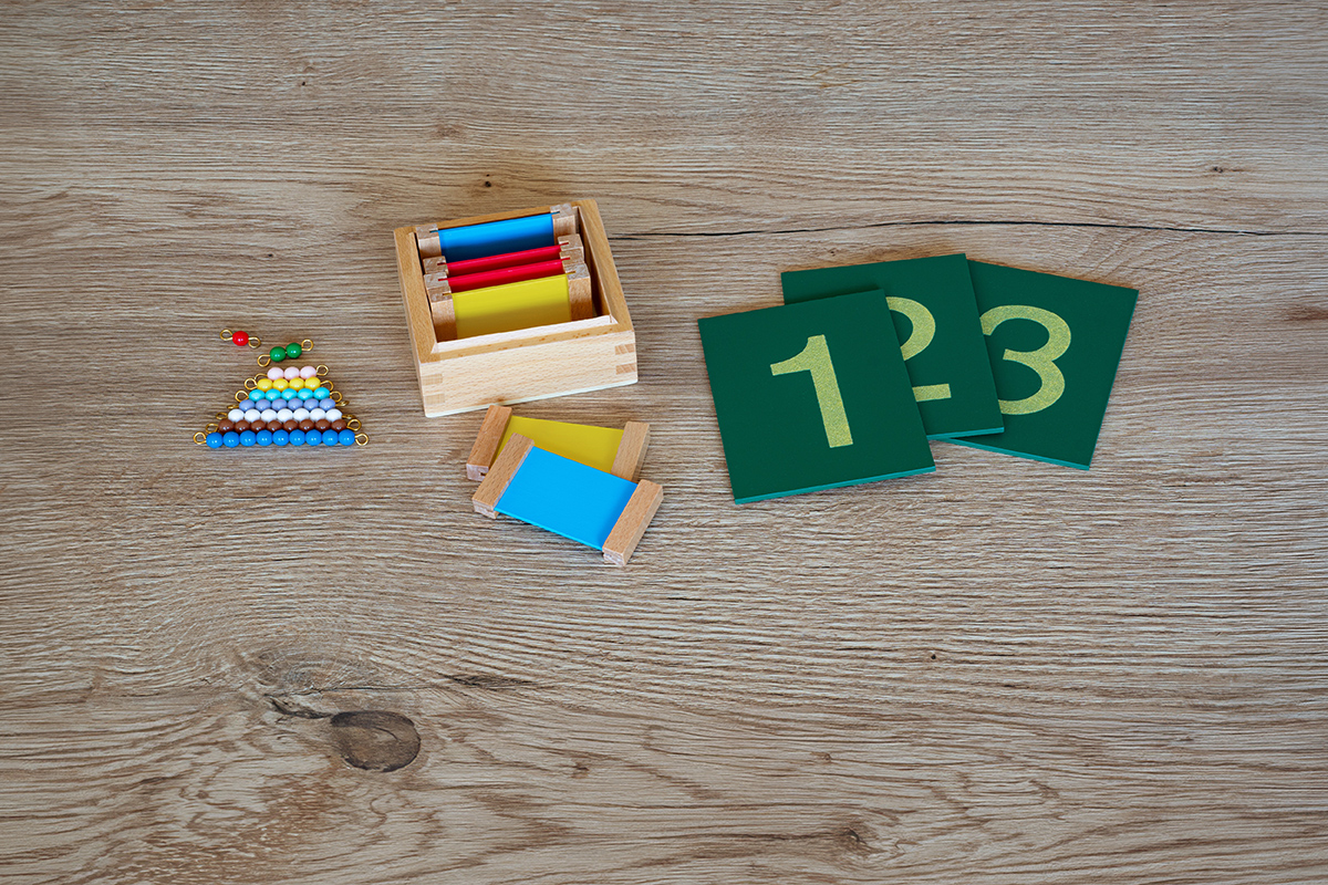 Auf einen Tisch liegen Farbtäfelchen, Sandpapier Ziffern und farbige Perlentreppe