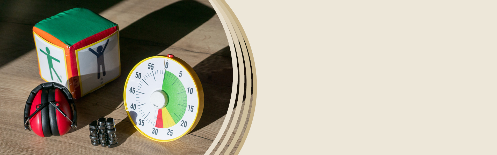 Auf einem Tisch liegen ein Gehörschutz rot, eine Zeitdauer-Uhr und Magnetische Steine