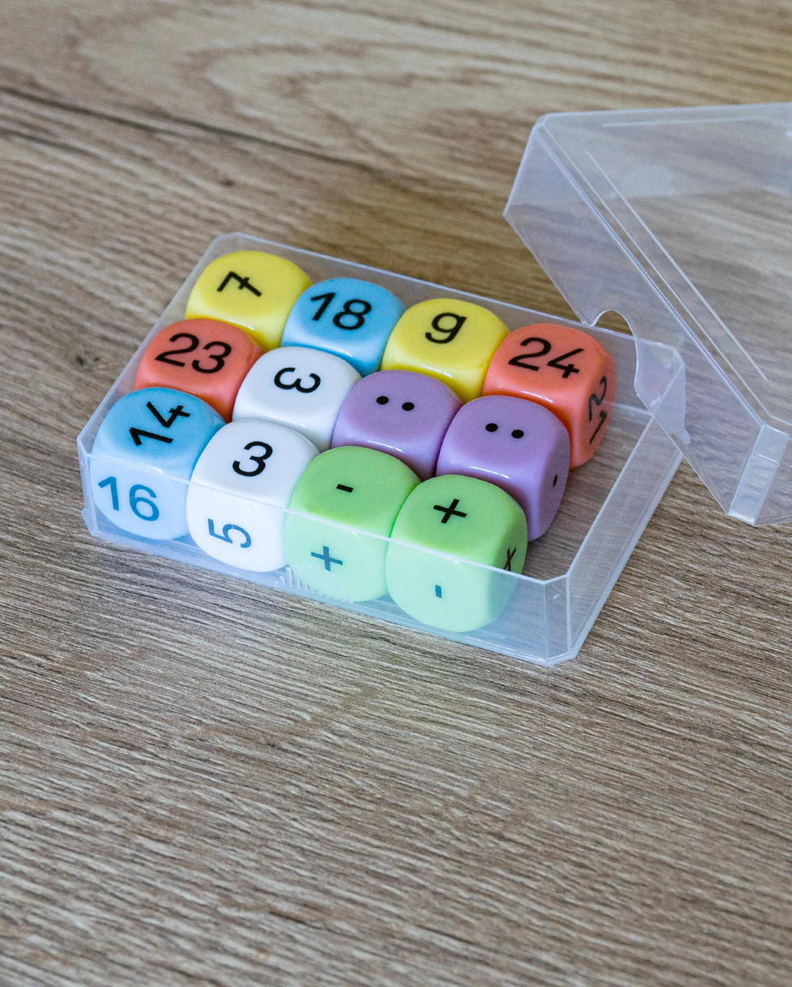 Buntes Würfelset mit Zahlen und Rechenzeichen in einer transparenten Kunststoffbox