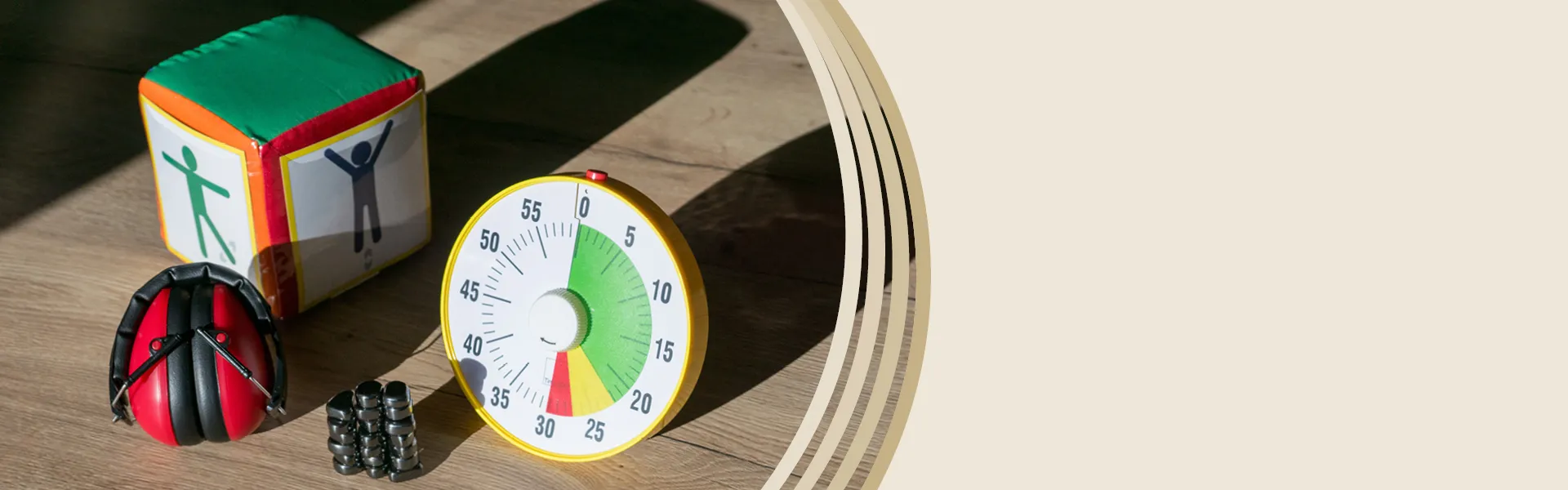 Auf einem Tisch liegen ein Gehörschutz rot, eine Zeitdauer-Uhr und Magnetische Steine