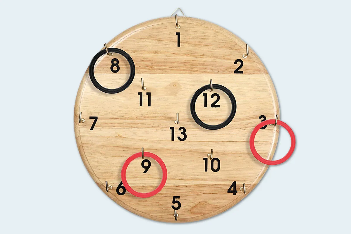 Holzscheibe mit Zahlen und kleinen Haken daneben, an manchen hängen Ringe