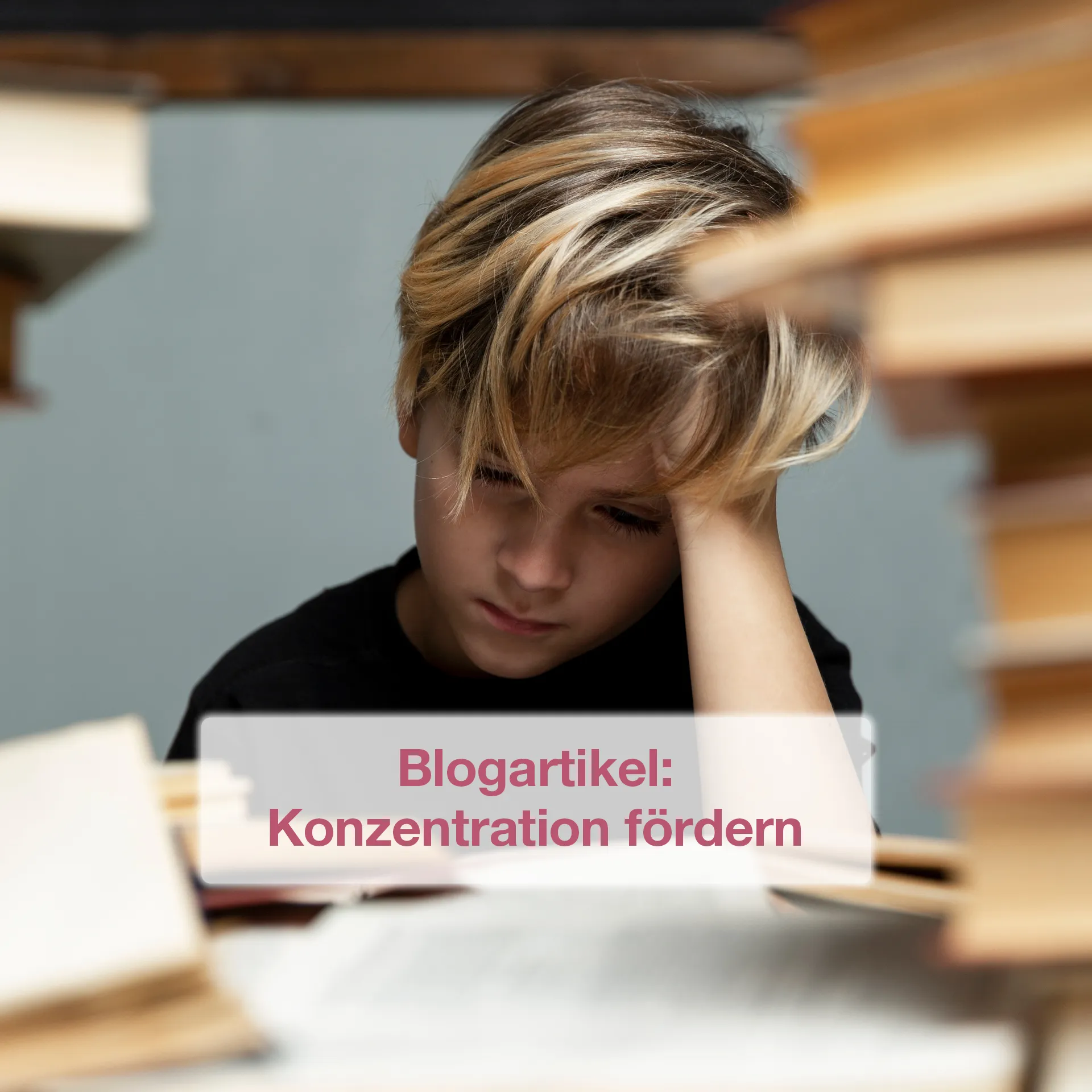 Kind sitzt über Buch gebeugt an einem Schreibtisch
